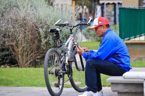 Man sitting down with bicycle Stock Photos