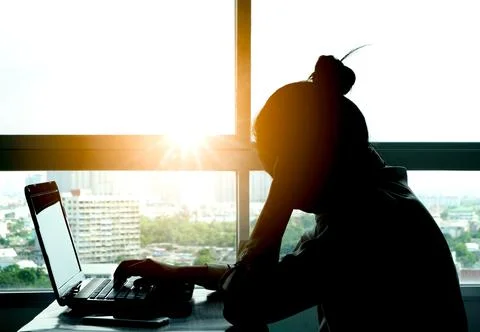 A man sitting down, his face unsettled. At the computer desk He has headaches Stock Photos