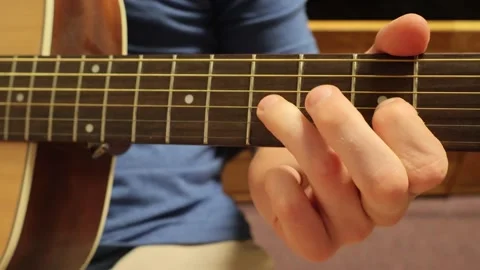 Man sitting down playing guitar fingerstyle Stock Footage 279909199