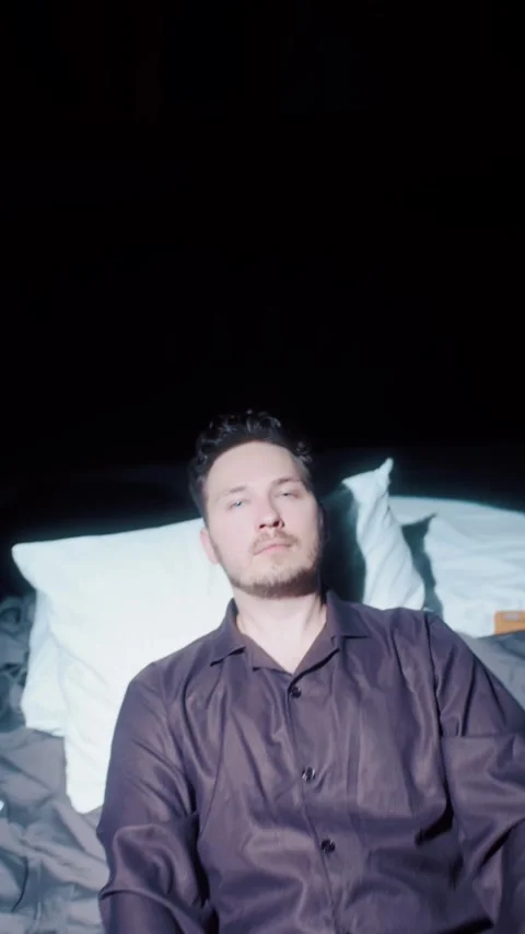 Man Sitting Down Then Lying Back on Bed Vídeos de archivo 322897789