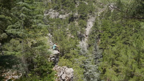 Man sitting on the edge of a cliff Stock Footage 307926773