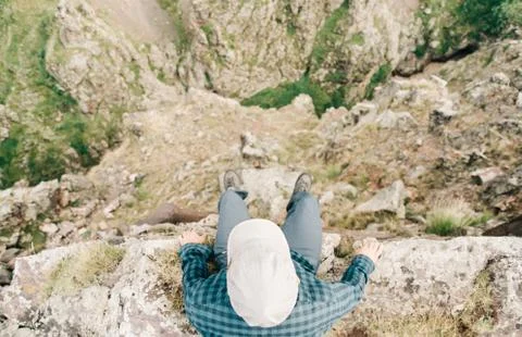 Man sitting on edge of cliff. Stock Photos
