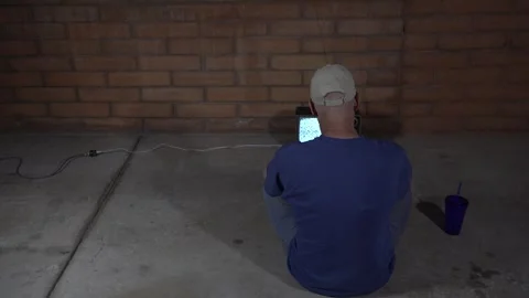 A man sitting in an empty room watching static on a vintage TV set Video stock 240867174
