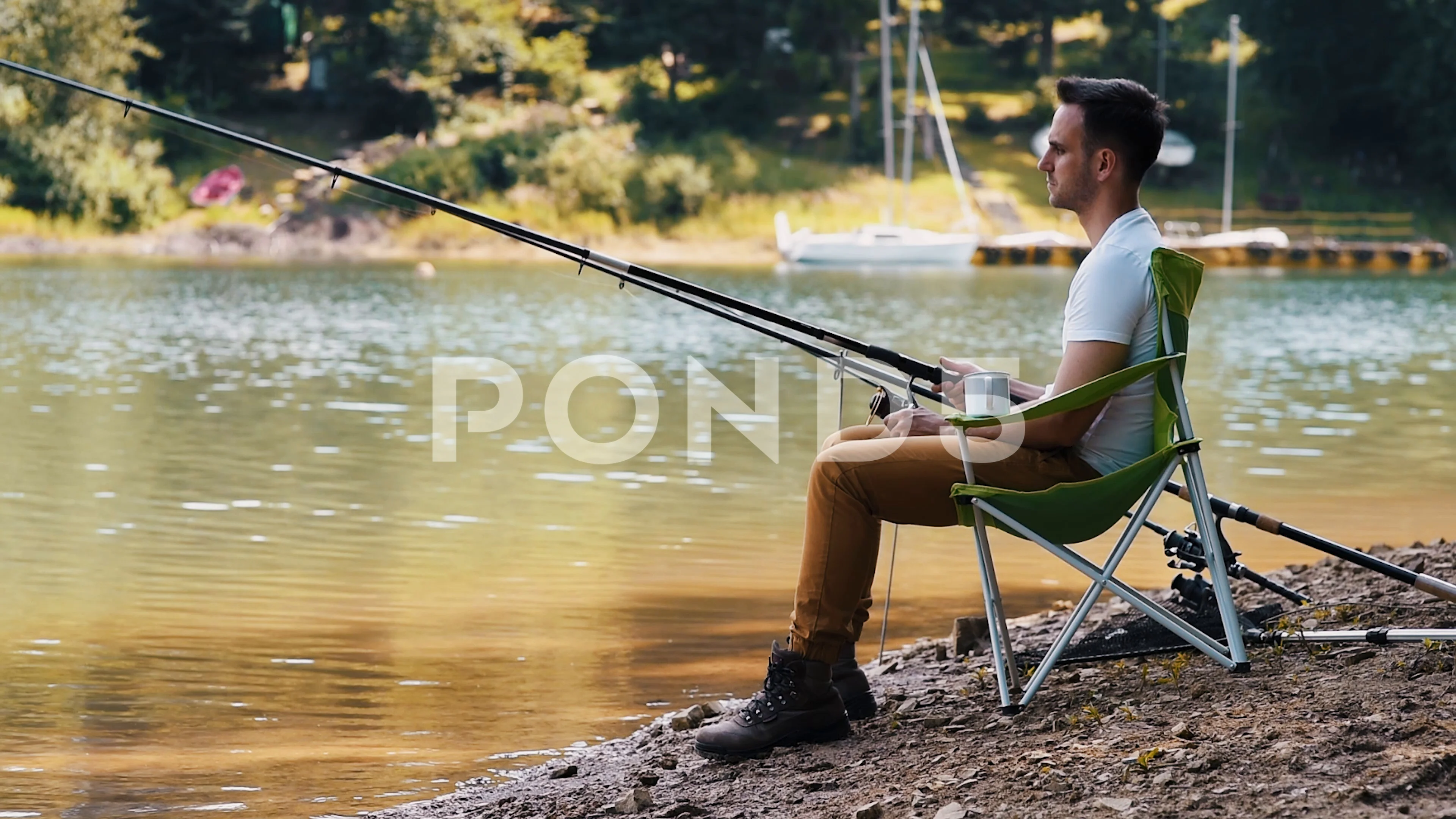 Man sitting on fishing chair and fishing, Stock Video
