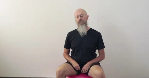 Man sitting on fitnes ball doing neck spine exercise Stock Footage 240877737