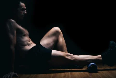 Man sitting on the floor doing stretching exercises Stock Photos