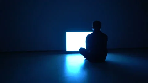 The man sitting on the floor in front of the television Stock Footage 98313355