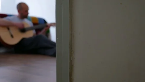 Man sitting on floor taking an online guitar lessons during Coronavirus confi Stock Footage 128970826