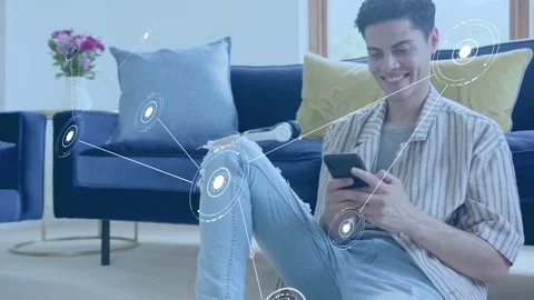 Man sitting on floor using phone, node appearing left, network linking to phone, Stock Footage 333911305