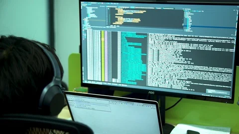 A man sitting in front of a computer coding in a digital software on a computer Stock Footage 96225788