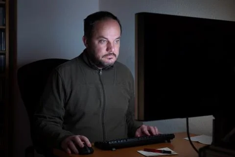 Man sitting in front of computer at night Stock Photos