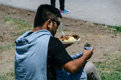 Man sitting on the grass eating Stock Photos