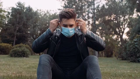 A man is sitting on the grass in the park. Stock Footage 131667575