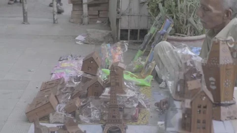 A man sitting on the ground selling handmade items in Karachi, Pakistan Stock Footage 343875822