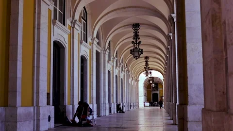 A man sitting on the ground under the porch in Praca do Commercio. Lisbon Stock Footage 138036822
