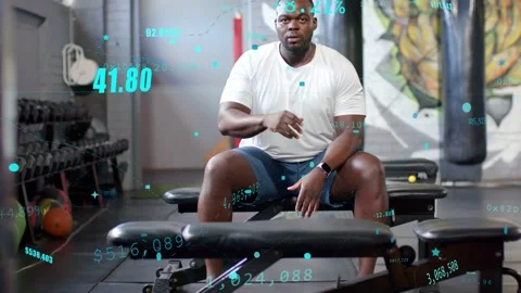 Man sitting gym bench after set shifting rubbing brow resting while teal data Video stock 334203870