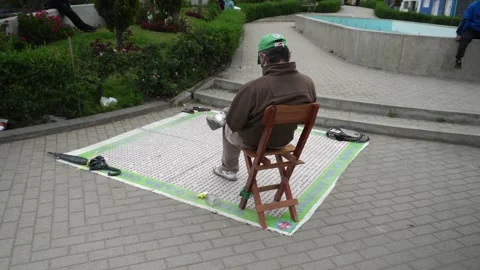 A man sitting in his chair playing a game of luck on the floor to throw coins Vidéo 164567167