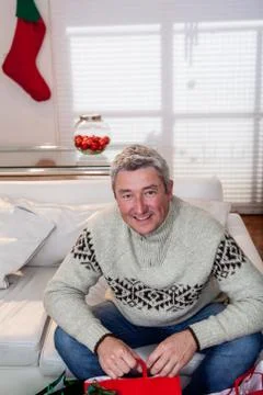 Man sitting in his couch preparing de gifts christmas Stock Photos