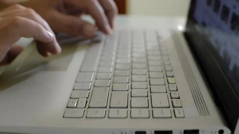 A man is sitting at home at a table and surfing the Internet at a laptop Vídeo Stock 145626925