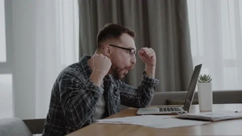 Man sitting at home table, looking at laptop screen, feels pleased with pride Stock Footage 155078623