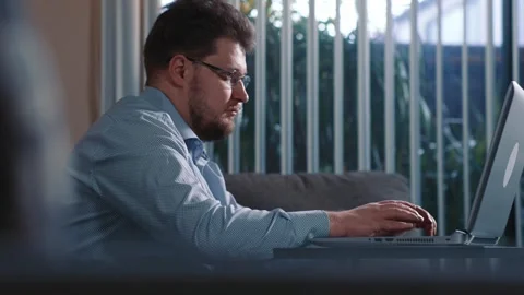 Man sitting at home working on laptop computer Stock Footage 340206938