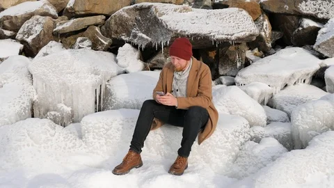 Man sitting on the ice and talking on the phone Stock-Footage 101317094