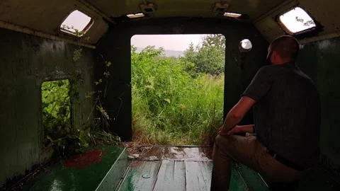 Man Sitting Inside Abandoned Trailer Looking at Heavy Rain Storm Video stock 339590559