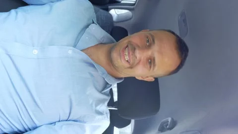 Man sitting inside the car behind the wheel looking at the camera and smiling Stock Footage 142508918
