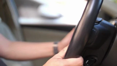 Man sitting inside the car, holding the steering wheel close-up. driver holding Видео 336265982