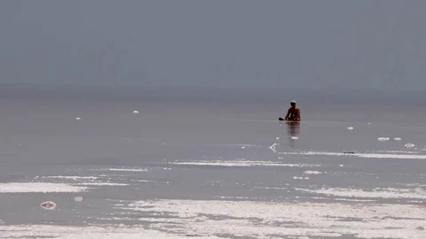 Man sitting inside crystal salty beach shore of red pink sea water, medication Video stock 70355684