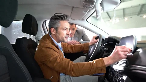 Man sitting inside vehicle in car dealership Video stock 72708574