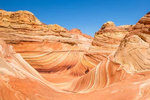 Man sitting inside the Wave feature of northern Arizona. Hiker stopping to en Stock Photos