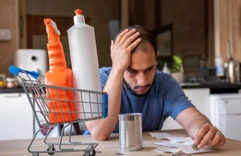 Man sitting in the kitchen feeling frustrated due inflation and increase of.. Stock Photos