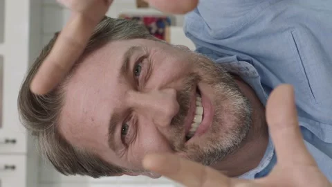 Man sitting in kitchen making frame gesture. Stock Footage 196163708