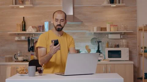 Man sitting in kitchen switch off the lights using voice command Stockfoto's