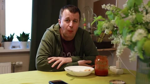 Man Sitting at Kitchen Table With Empty Plate and Tomato Sauce During Dinner Video stock 273602466