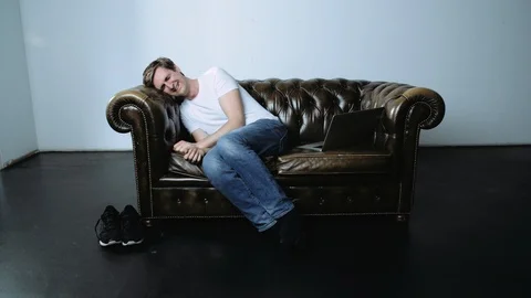 Man Sitting on Leather Sofa and Laughing Stock Footage 120133038