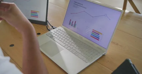 Man sitting left at wooden table, after chart update tapping and typing on Stock Footage 336784918