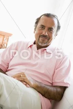 Man sitting in living room smiling (high key) Stock Photos
