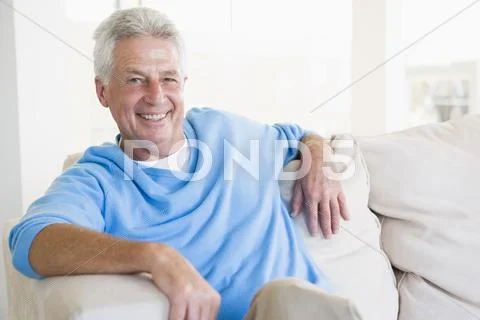 Man sitting in living room smiling Stock-Fotos