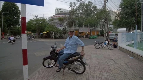 Man sitting on a moped Stock Footage 73504360