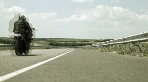 Man sitting on the motorcycle and moving on the road Stock Footage