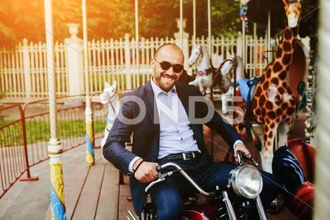 Man sitting at motorcycle on the carousel Stock Photos