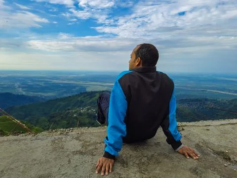 Man sitting at mountain top with dramatic sky at morning Photos