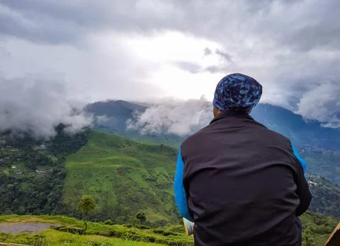 Man sitting at mountain top with dramatic sky at morning 스톡 사진