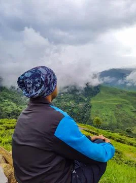 Man sitting at mountain top with dramatic sky at morning Foto stock