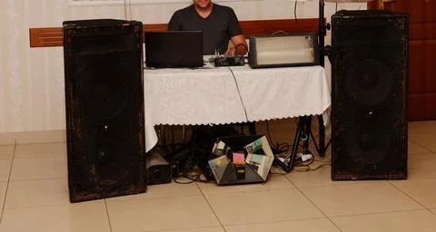 A man is sitting at the music control panel, dancing is not visible, his face is Stock Photos