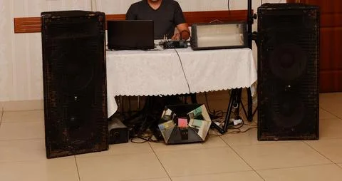 A man is sitting at the music control panel, dancing is not visible, his face is Stock Photos