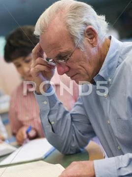 Man sitting near woman in library with books and notepads (selective focus) Stock Photos