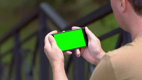 Man sitting next to railing reading an a mobile Stock Footage 112153048